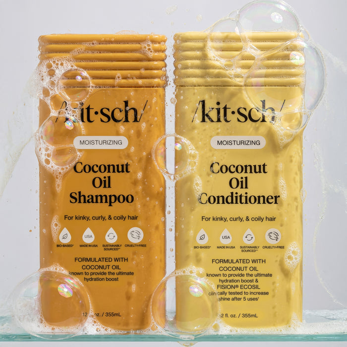 KITSCH Moisturizing Coconut Oil Shampoo & Conditioner Combo bottles surrounded by bubbles and lather on grey background