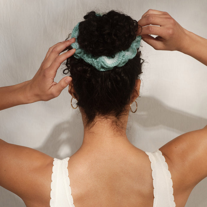 Model with curly hair in updo secured with Kitsch Seafoam blue Crochet Scrunchie