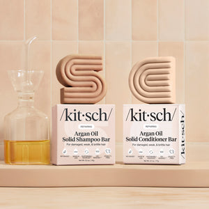 Lifestyle styling of Kitsch Repairing Argan Oil Shampoo & Conditioner Bar Combo with argan nuts and warm props