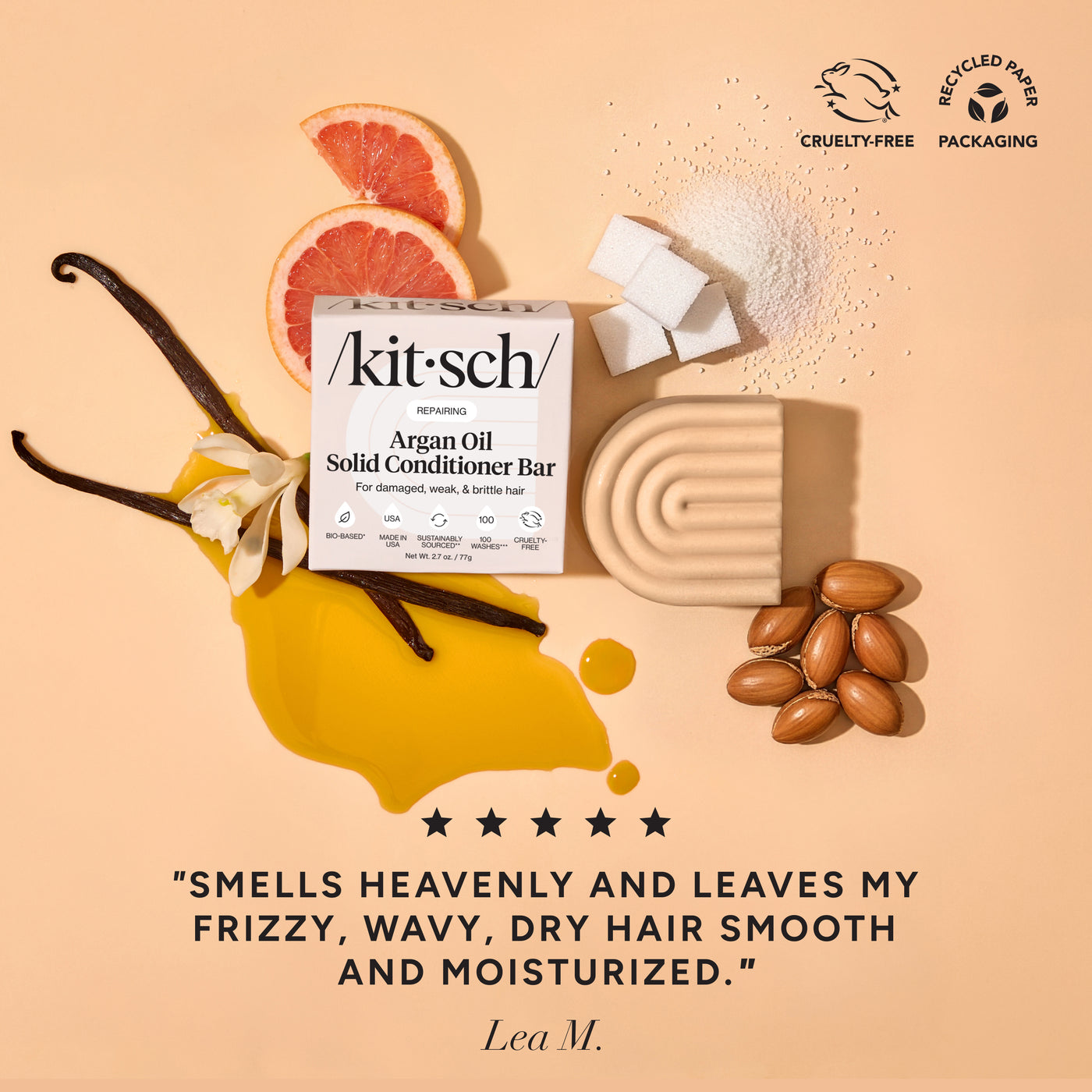 KITSCH Repairing Argan Oil Conditioner Bar — ingredient flat lay on warm golden background with vanilla pod, grapefruit slices, almonds, and sugar cubes — 5-star review: SMELLS HEAVENLY AND LEAVES MY FRIZZY, WAVY, DRY HAIR SMOOTH AND MOISTURIZED. — Lea M. — Cruelty-Free | Recyclable Paper Packaging — Enriched with PhytoVie® Defense to aid in recovery for damaged hair