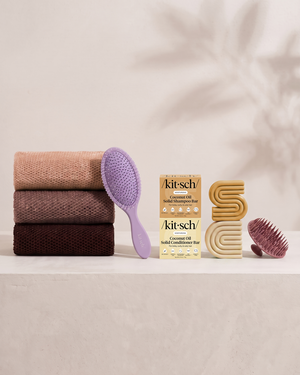Kitsch Spring Welcome Kit Coconut Oil shown as a full bundle with the Moisturizing Coconut Oil Shampoo and Conditioner Bars, Soft Violet Wet/Dry Brush, Terracotta Scalp Exfoliator and Rosewood African Net Sponge on a soft neutral background